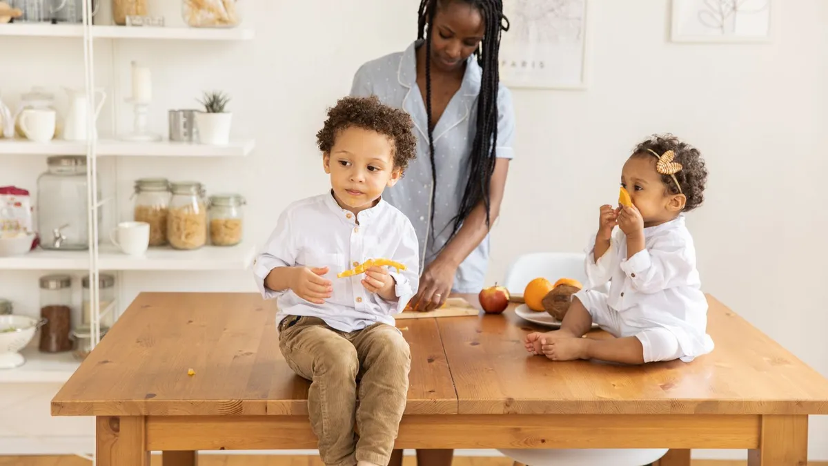 Calm family kitchen where a single parent has laid out bills to plan debt help