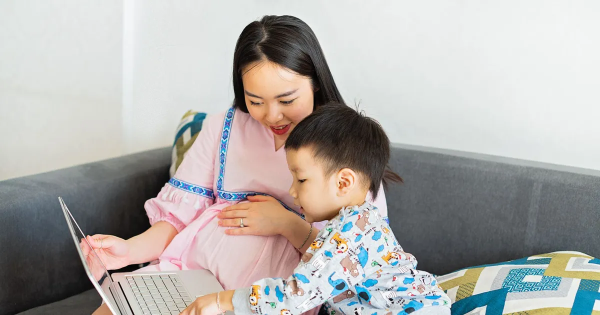 Mother and child at a laptop looking up debt help for single mothers in Canada